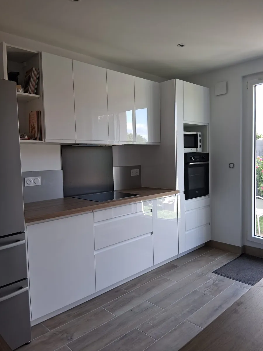 Cuisine blanche laquee equipee avec four encastre et plan de travail bois, en Essonne