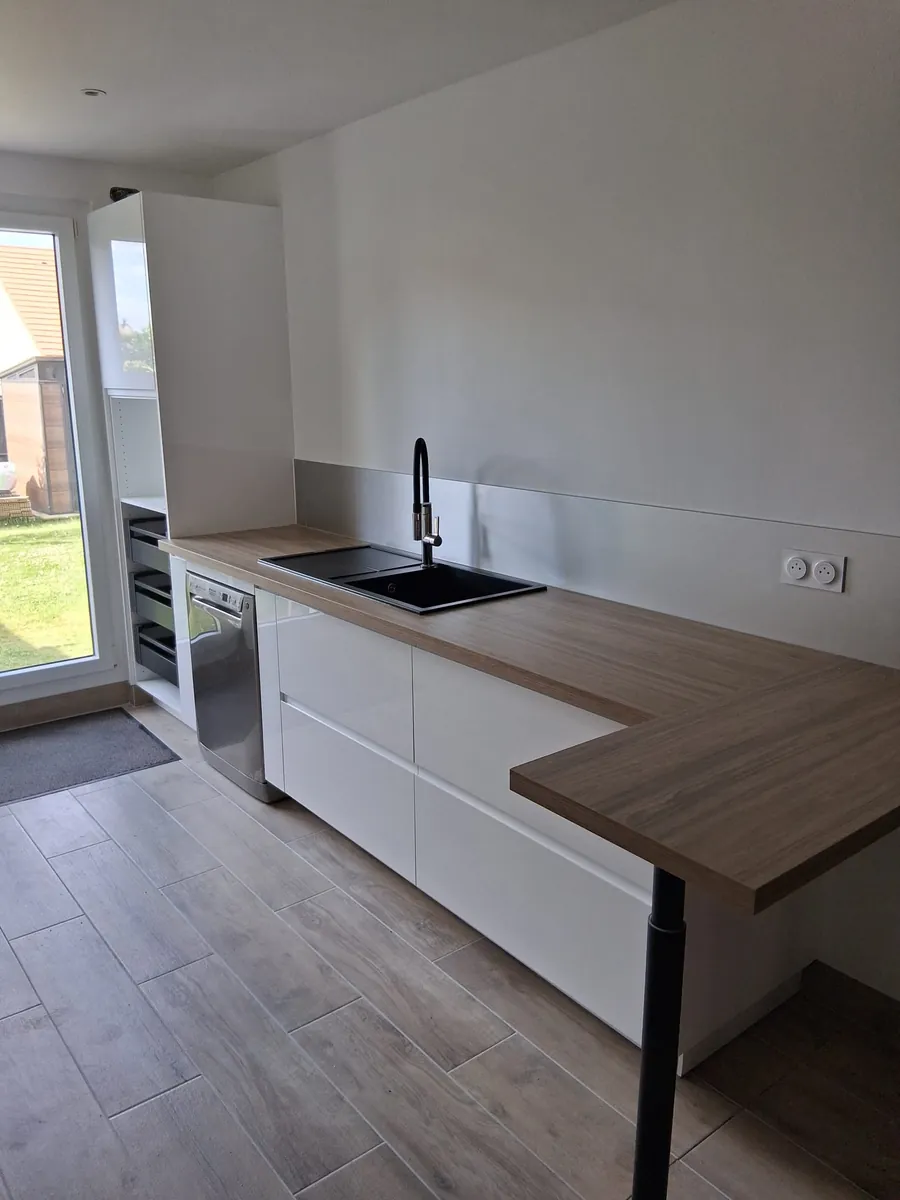 Plan de travail bois avec evier noir dans une cuisine renovee en Essonne