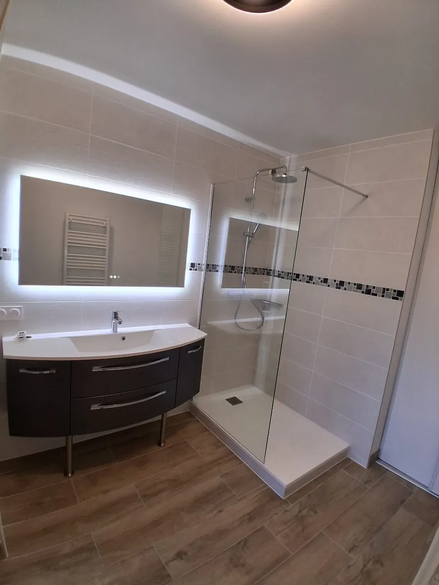 Salle d'eau renovee avec douche italienne, meuble vasque gris et miroir retroeclaire, en Essonne